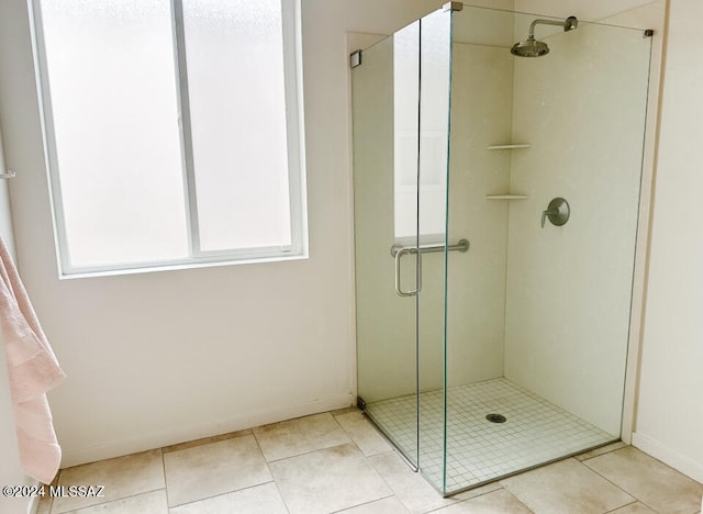 bathroom with tile patterned flooring, an enclosed shower, and a wealth of natural light