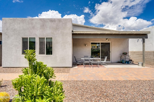 rear view of property with ceiling fan and a patio