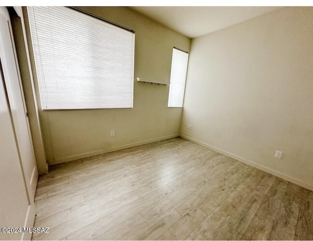 spare room with light wood-type flooring and a healthy amount of sunlight