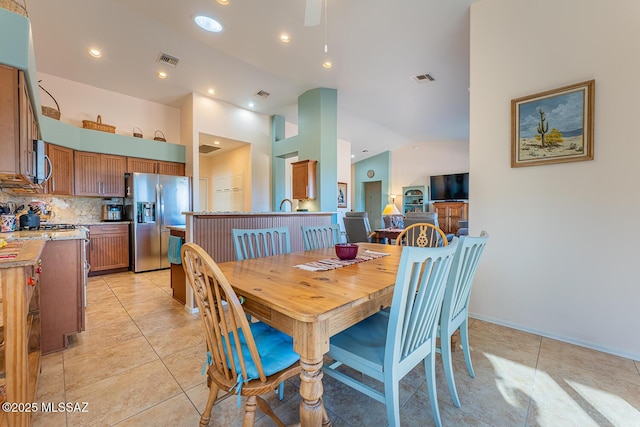 tiled dining room with high vaulted ceiling