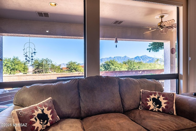 living room with a mountain view and ceiling fan