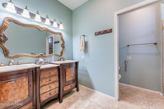 bathroom with tile patterned flooring, vanity, and toilet