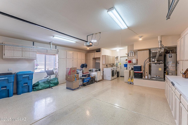 garage with washing machine and clothes dryer, a garage door opener, heating unit, and gas water heater