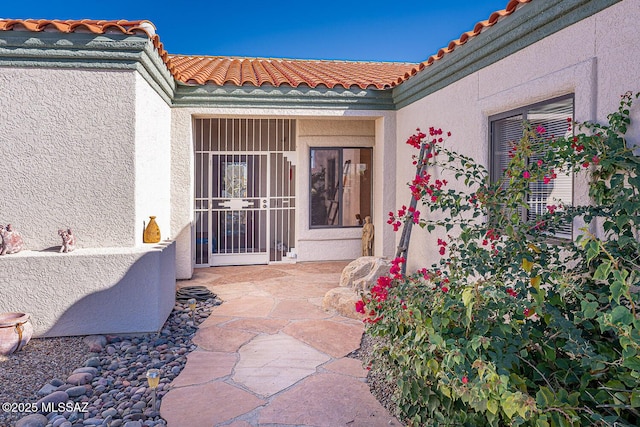 view of exterior entry with a patio