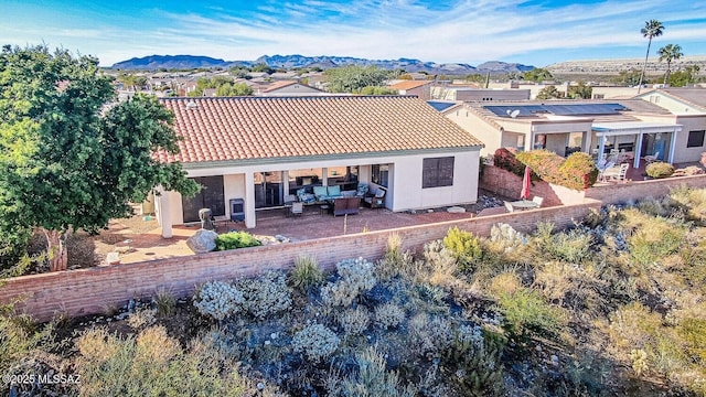 back of property with an outdoor living space and a mountain view