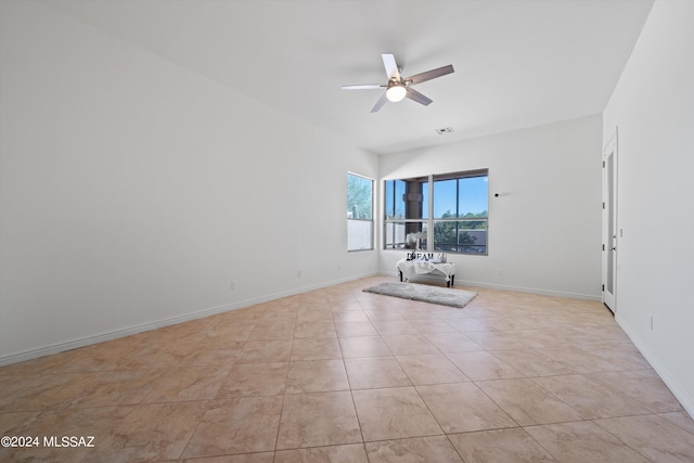 spare room featuring light tile patterned floors, visible vents, baseboards, and ceiling fan