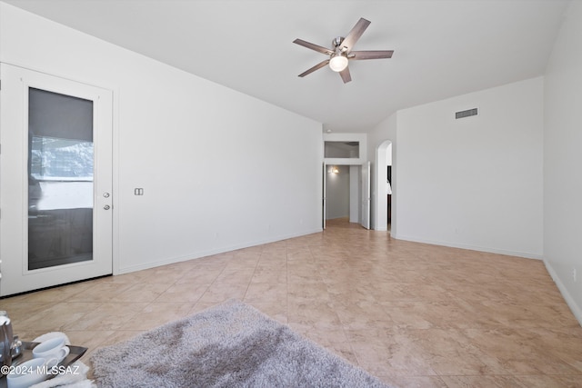 empty room with arched walkways, visible vents, baseboards, and ceiling fan