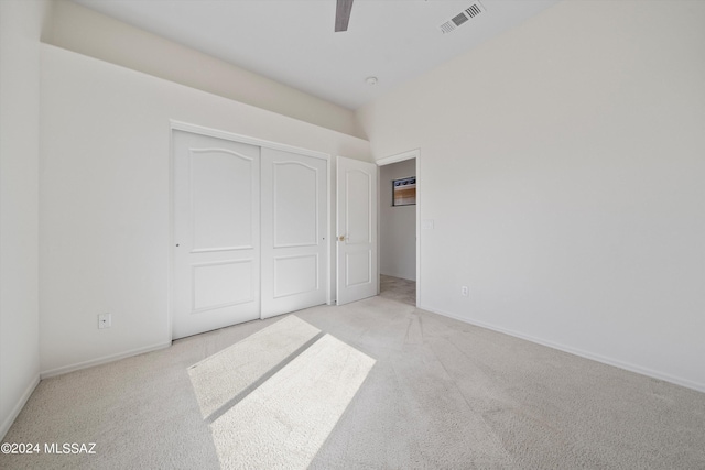 unfurnished bedroom with baseboards, visible vents, a closet, and light carpet