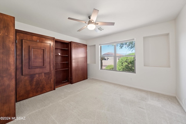 unfurnished bedroom featuring visible vents, baseboards, light colored carpet, and ceiling fan