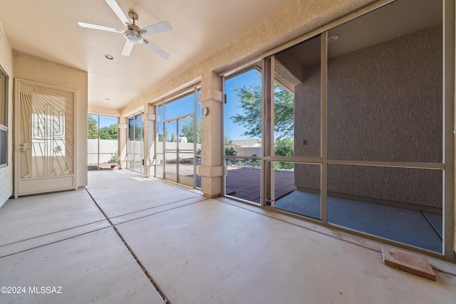 unfurnished sunroom with a ceiling fan