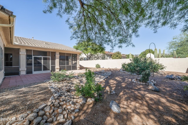 view of yard featuring a patio area, fence private yard, and a sunroom