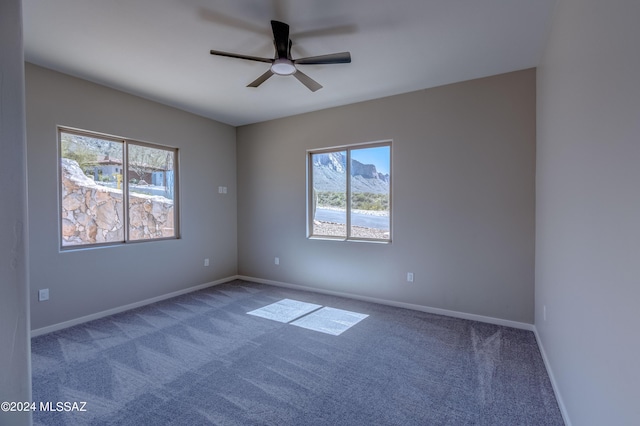 carpeted empty room with ceiling fan and a healthy amount of sunlight