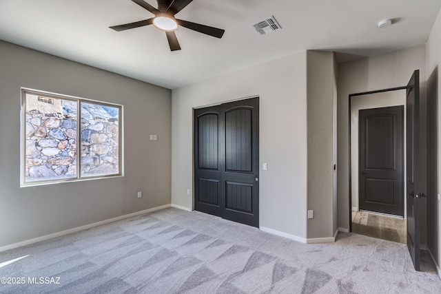 unfurnished bedroom featuring light carpet and ceiling fan