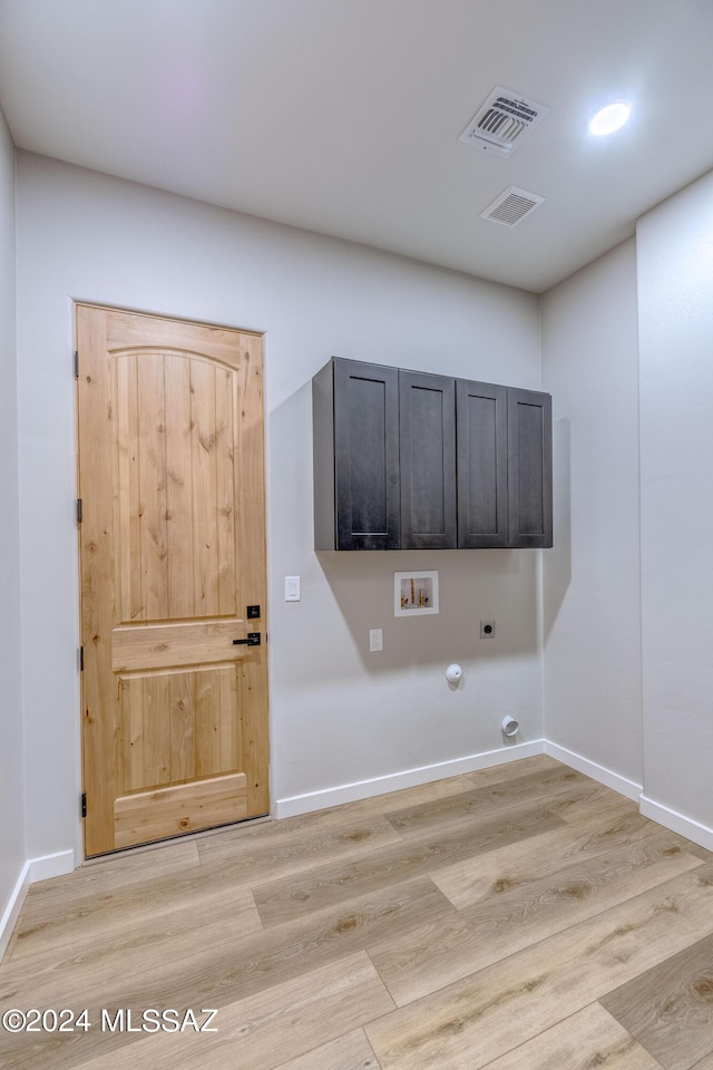 laundry room with cabinets, hookup for an electric dryer, light hardwood / wood-style floors, and hookup for a gas dryer