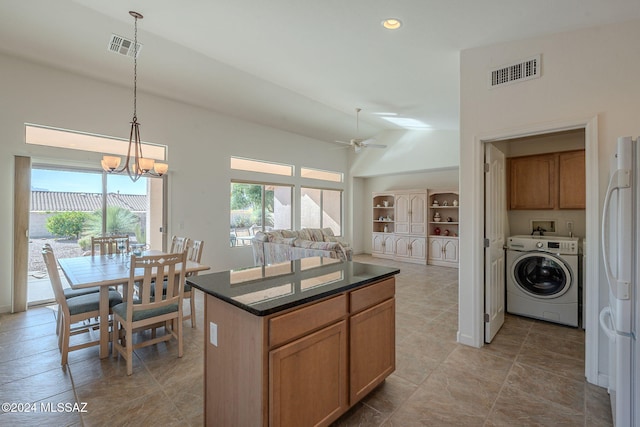 kitchen featuring a center island, washer / clothes dryer, white fridge, lofted ceiling, and decorative light fixtures