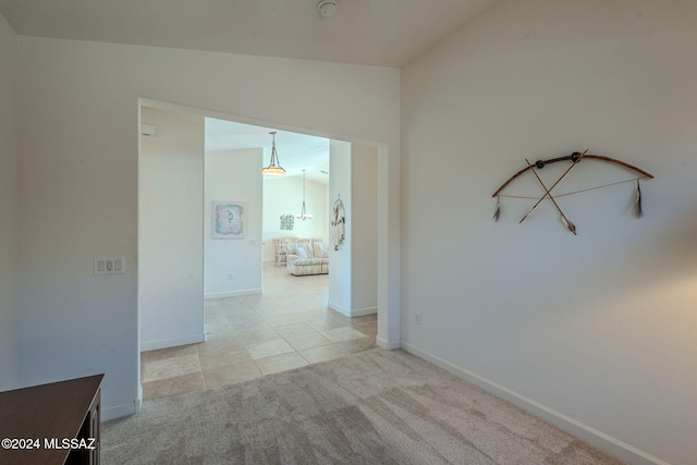 corridor featuring lofted ceiling and light carpet