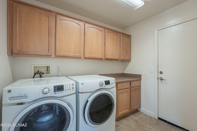 laundry room featuring cabinets, light tile patterned floors, and washer and clothes dryer