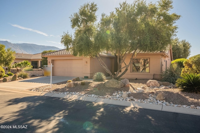 view of front of home with a mountain view and a garage