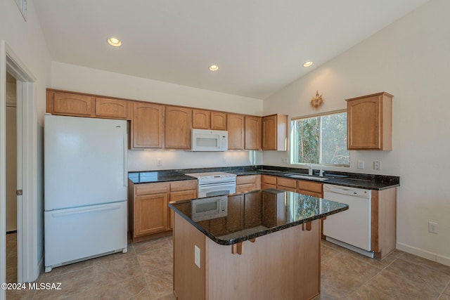 kitchen with white appliances, dark stone counters, sink, vaulted ceiling, and a kitchen island