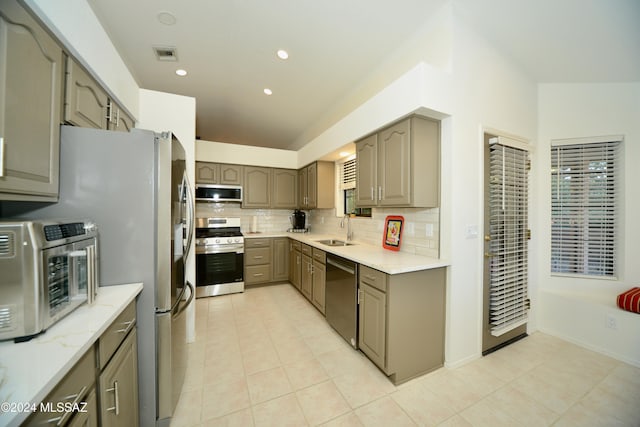 kitchen featuring decorative backsplash, sink, light tile patterned floors, and stainless steel appliances