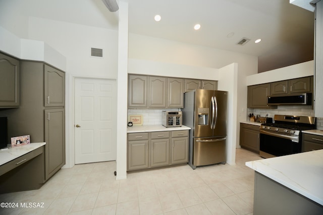 kitchen with appliances with stainless steel finishes, backsplash, and gray cabinetry