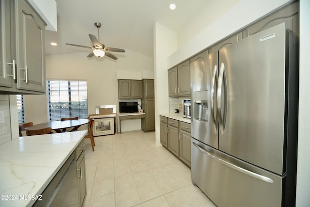 kitchen with appliances with stainless steel finishes, gray cabinets, decorative backsplash, and light stone counters