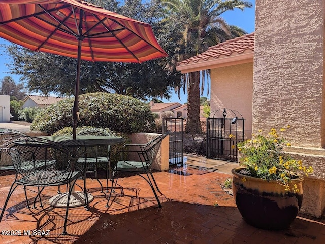 view of patio / terrace featuring outdoor dining area and a gate