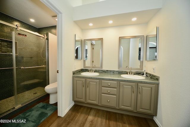 bathroom with hardwood / wood-style floors, vanity, toilet, and walk in shower