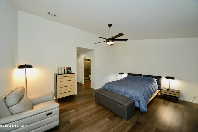 bedroom featuring dark wood-style floors, baseboards, visible vents, and arched walkways