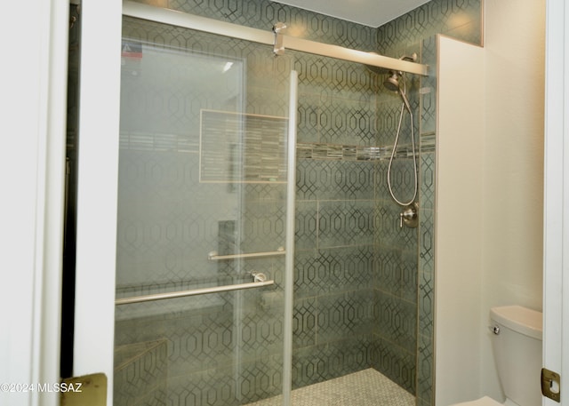 bathroom with a shower stall and toilet