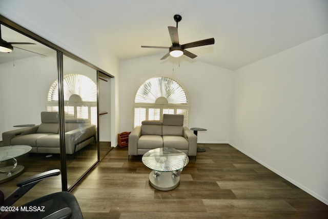 living area featuring dark wood-type flooring, vaulted ceiling, ceiling fan, and baseboards