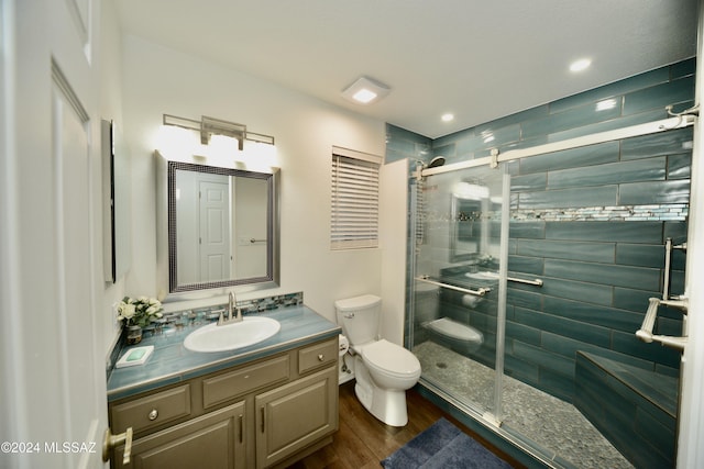 full bathroom featuring toilet, a shower stall, wood finished floors, and vanity