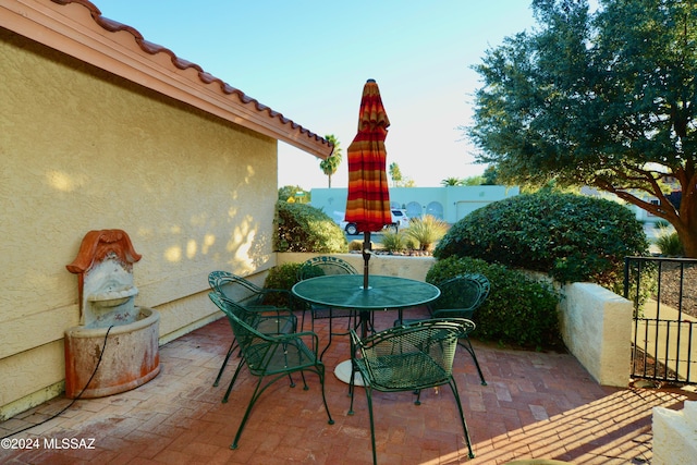 view of patio featuring outdoor dining area and fence