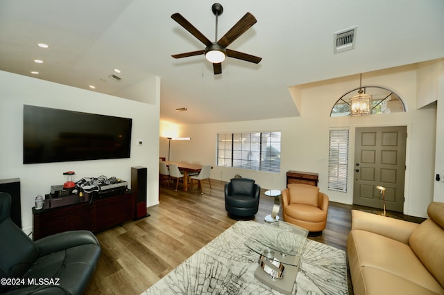 living area with recessed lighting, visible vents, wood finished floors, vaulted ceiling, and ceiling fan with notable chandelier