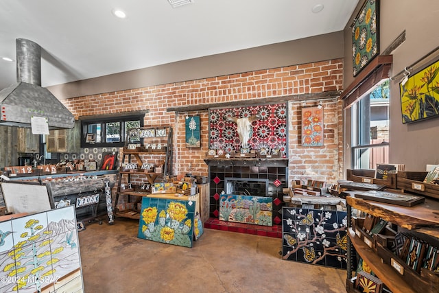 living room with a fireplace, concrete floors, and brick wall