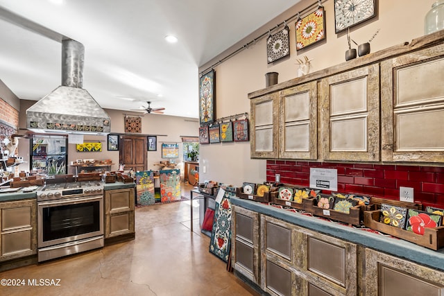 kitchen featuring decorative backsplash, ceiling fan, island exhaust hood, and stainless steel stove