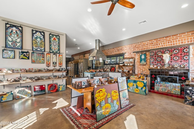 dining area with ceiling fan, concrete flooring, and brick wall