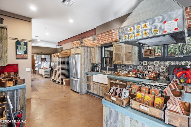 kitchen with sink, tasteful backsplash, concrete floors, exhaust hood, and appliances with stainless steel finishes