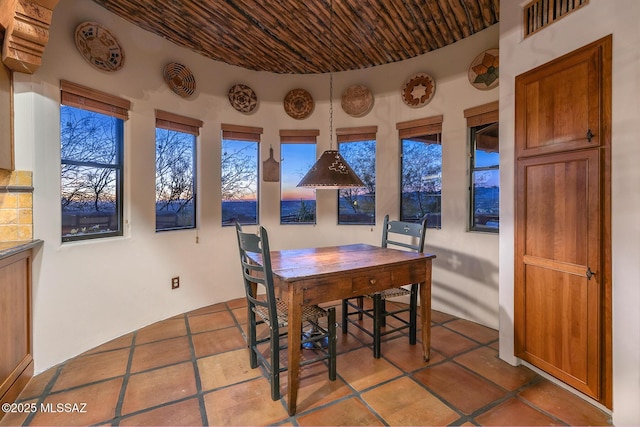 dining room with tile patterned flooring and wood ceiling