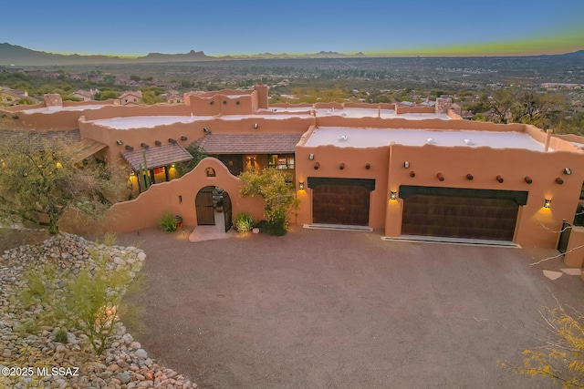 adobe home featuring a garage and a mountain view