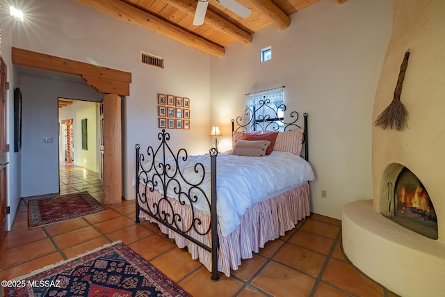 bedroom with beam ceiling, tile patterned floors, and wood ceiling