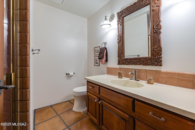 bathroom featuring vanity, decorative backsplash, tile patterned floors, and toilet