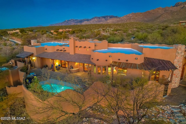 view of pool with a mountain view and a patio