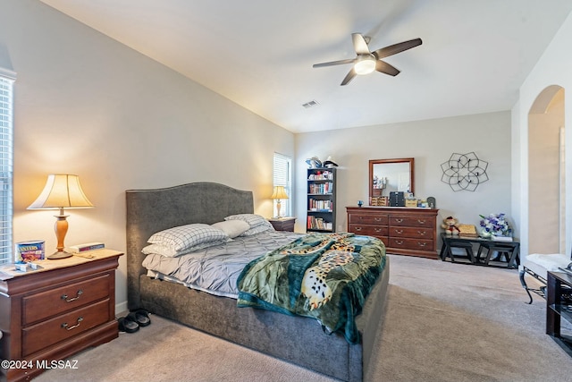 carpeted bedroom with ceiling fan, lofted ceiling, and multiple windows