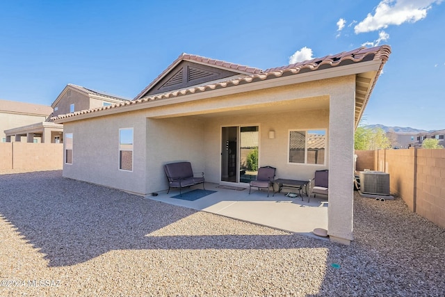 rear view of property with central AC, a patio area, and a mountain view