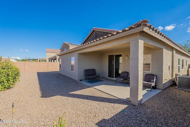 rear view of property with cooling unit and a patio