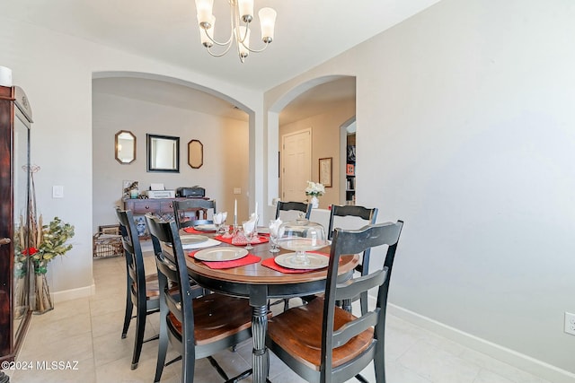 dining space with light tile patterned floors and an inviting chandelier