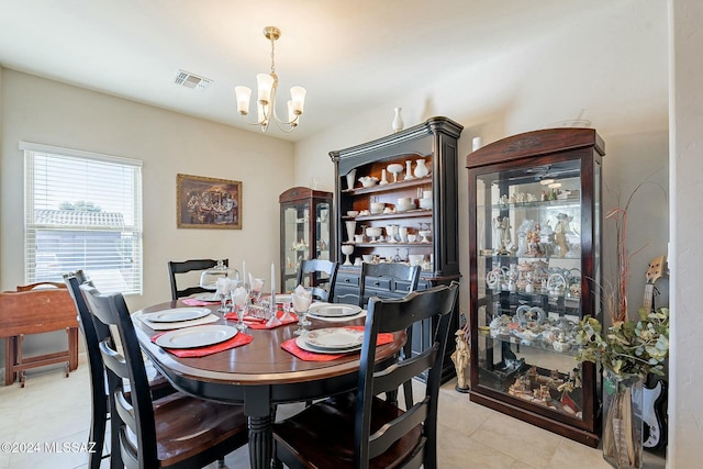 tiled dining room with a notable chandelier