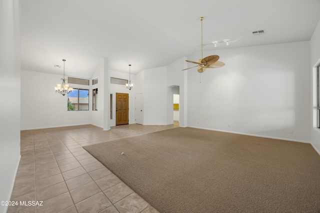 unfurnished living room featuring light tile patterned floors, ceiling fan with notable chandelier, and high vaulted ceiling