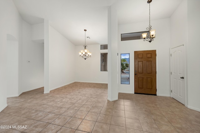 tiled foyer entrance featuring a high ceiling and an inviting chandelier